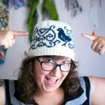 Mandy Bee in her Put a Bird on My Cuppa - a unique, complex stranded colorwork knitted hat pattern